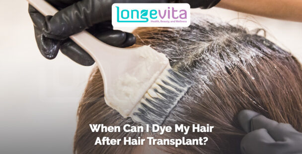 close-up of hair dye being applied to a person’s scalp with a brush