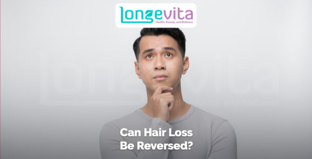 thoughtful man touching his chin with text asking can hair loss be reversed