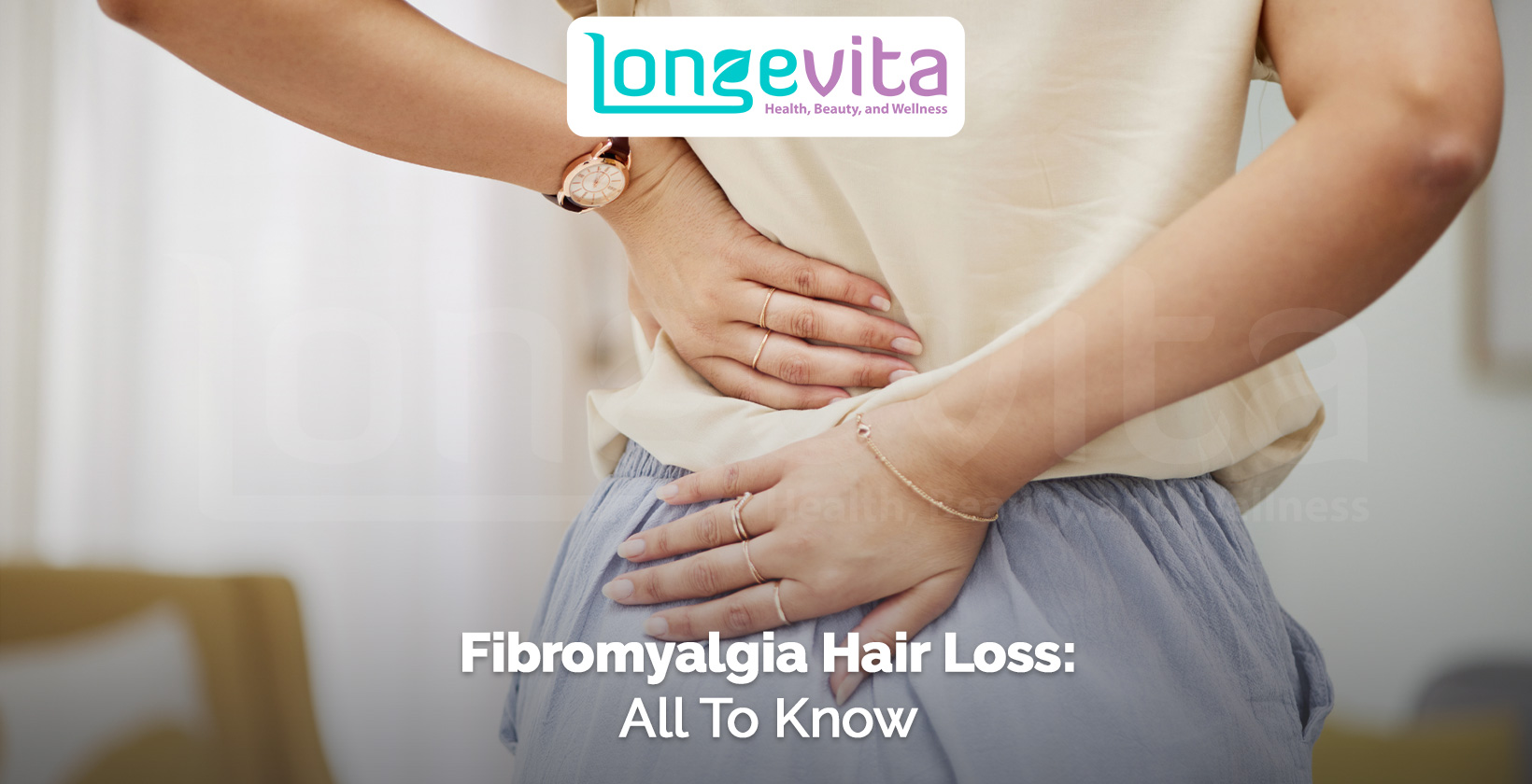 woman holding her lower back in pain, symbolizing fibromyalgia discomfort