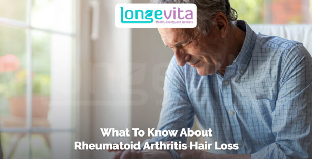 older man sitting indoors holding his hand in discomfort