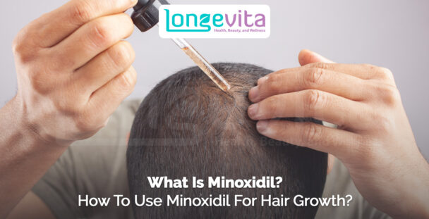 close-up of a person applying minoxidil with a dropper on scalp