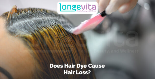 close-up of hair dye being applied to roots with a brush