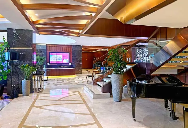 stylish lobby interior of Movenpick Hotel with staircase, piano, and modern decor