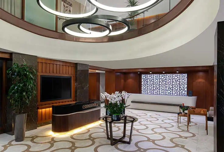 modern lounge area at Movenpick Hotel with elegant furniture, TV, and decorative lighting