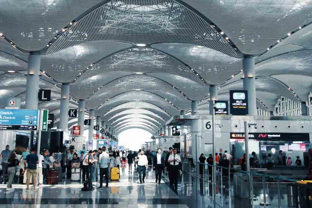 crowded interior of Istanbul Airport departures hall with shops and travelers