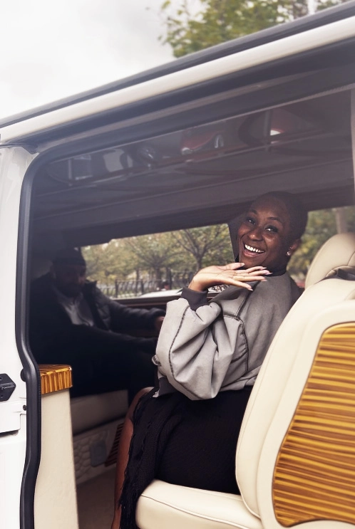 hair transplant patient smiling and waving while seated in the back of a luxury van transfer
