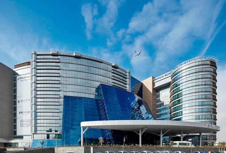 daytime exterior of Pullman Istanbul Airport Hotel with modern glass architecture and blue sky
