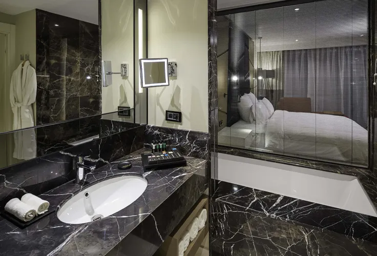 modern marble bathroom at Pullman Istanbul Airport Hotel with view into bedroom