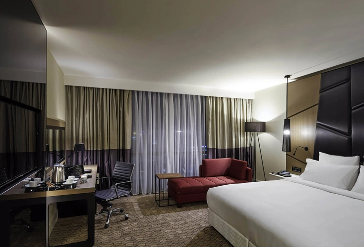 modern hotel room interior at Pullman Istanbul Airport Hotel with bed, desk, and seating area