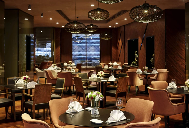 elegant restaurant interior at Pullman Istanbul Airport Hotel with set tables and warm lighting