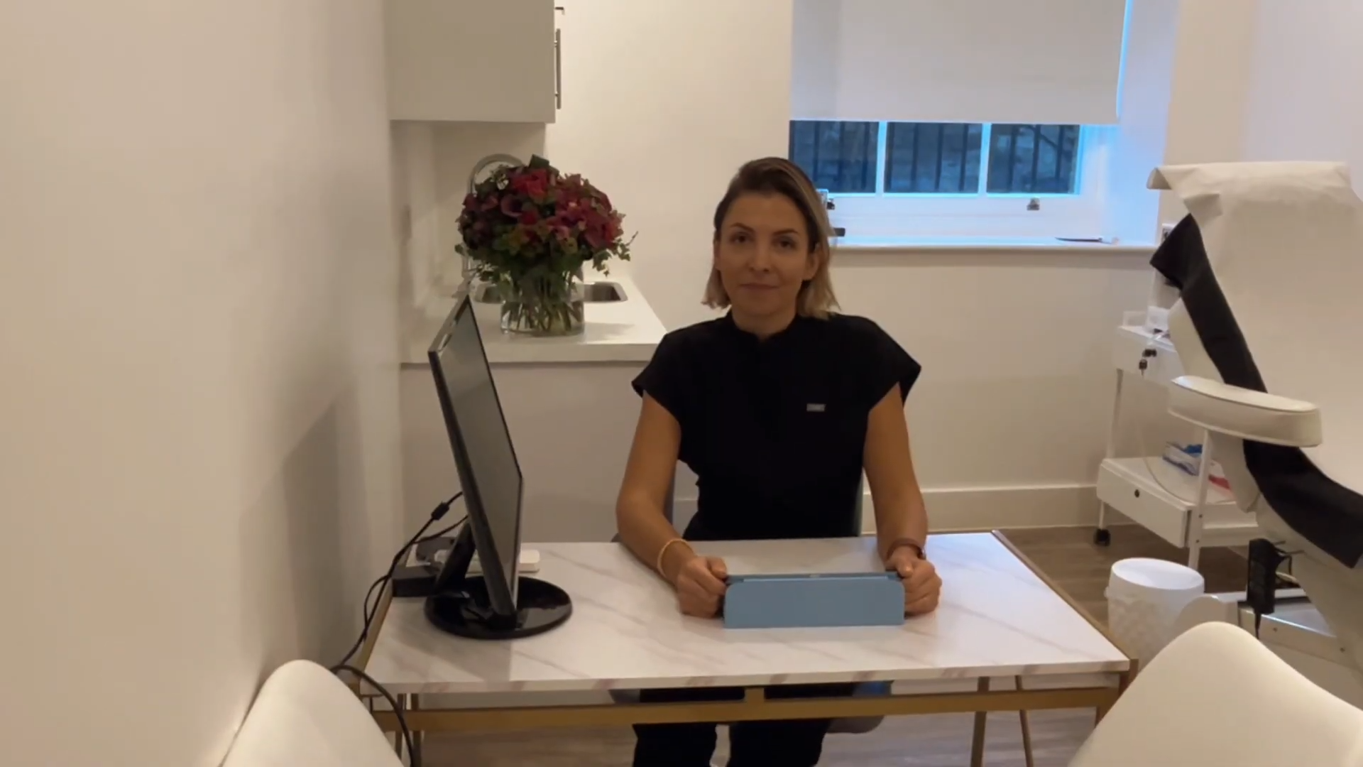 Dr Gizem Seymenoglu seated at a desk in Longevita Hair Transplant London clinic